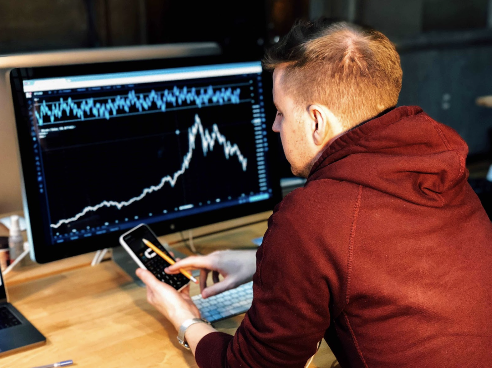 Person at computer with chart on screen